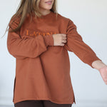 Handmade Sweater with fleece interior. Slits on the side for easy styling. Embroidered LATINA words on the front center